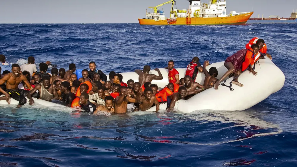 ﻿In this photo taken on Sunday, April 17, 2016 migrants ask for help from a dinghy boat as they are approached by the SOS Mediterranee's ship Aquarius, background, off the coast of the Italian island of Lampedusa. The European Union's border agency says the number of migrants crossing the Mediterranean Sea to Italy more than doubled last month. Frontex said in a statement on Monday that almost 9,600 migrants attempted the crossing, one of the most perilous sea voyages for people seeking sanctuary or jobs in Europe. (Patrick Bar/SOS Mediterranee via AP)