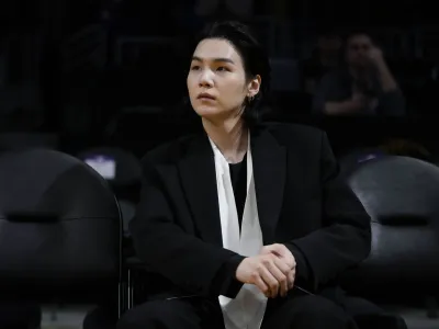 FILE - BTS member Suga attends an NBA basketball game between the Los Angeles Lakers and the Dallas Mavericks on Jan. 12, 2023, in Los Angeles. Suga has become the third member of BTS to begin South Korea's compulsory military service. BTS' label, Big Hit Music, said in a statement on Monday, Aug. 7, 2023, that Suga "has initiated the military enlistment process by applying for the termination of his enlistment postponement." (AP Photo/Jae C. Hong, File)