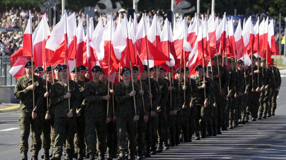 Members of the new voluntary Territorial Defense Troops march with Poland's national flags in a massive military parade to celebrate the Polish Army Day, commemorating the 1920 battle in which Polish troops defeated advancing Bolshevik forces, in Warsaw, Poland, Tuesday, Aug. 15, 2023. Poland is holding a military parade to showcase its state-of-the-art weapons and defense systems, as war rages across its southeastern border in neighboring Ukraine and ahead of parliamentary elections scheduled for Oct. 15. (AP Photo/Czarek Sokolowski)