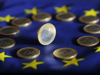 FILED - 04 July 2011, Karlsruhe: A view of euro coins on a Euro flag. Photo: Uli Deck/dpa