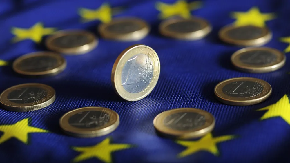 FILED - 04 July 2011, Karlsruhe: A view of euro coins on a Euro flag. Photo: Uli Deck/dpa