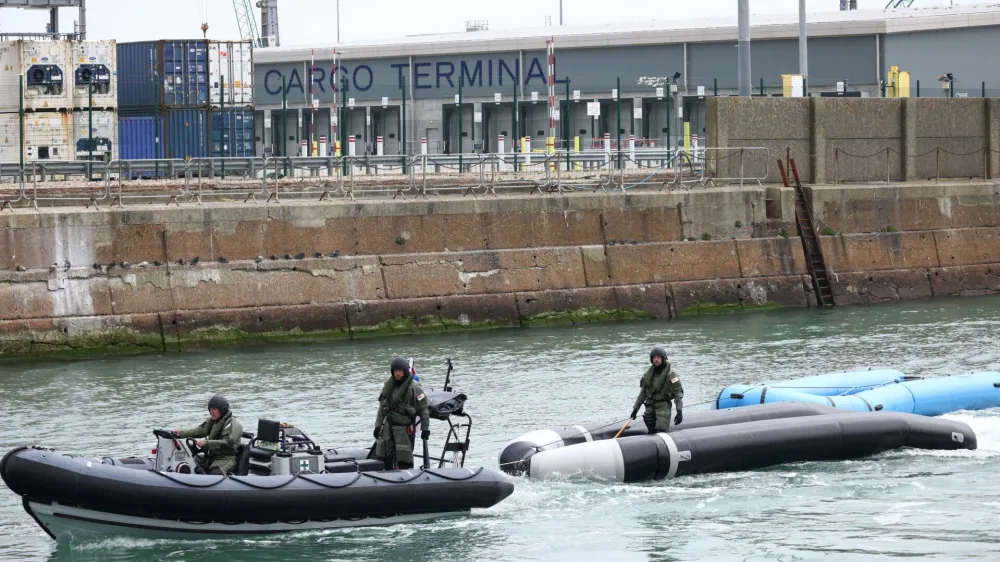 Military personnel tow dinghies used by migrant to cross the English Channel into Dover Harbour in Dover, Britain, May 1, 2022. REUTERS/Henry Nicholls