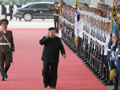 HANDOUT - 11 September 2023, North Korea, Pyongyang: A picture released by the North Korean state news agency (KCNA) on 12 September 2023 shows North Korea leader Kim Jong-un waving as he inspects an honor guard before boarding a train in Pyongyang to visit Russia to hold talks with Russian President Vladimir Putin. Photo: -/kcna/dpa - ATTENTION: editorial use only and only if the credit mentioned above is referenced in full