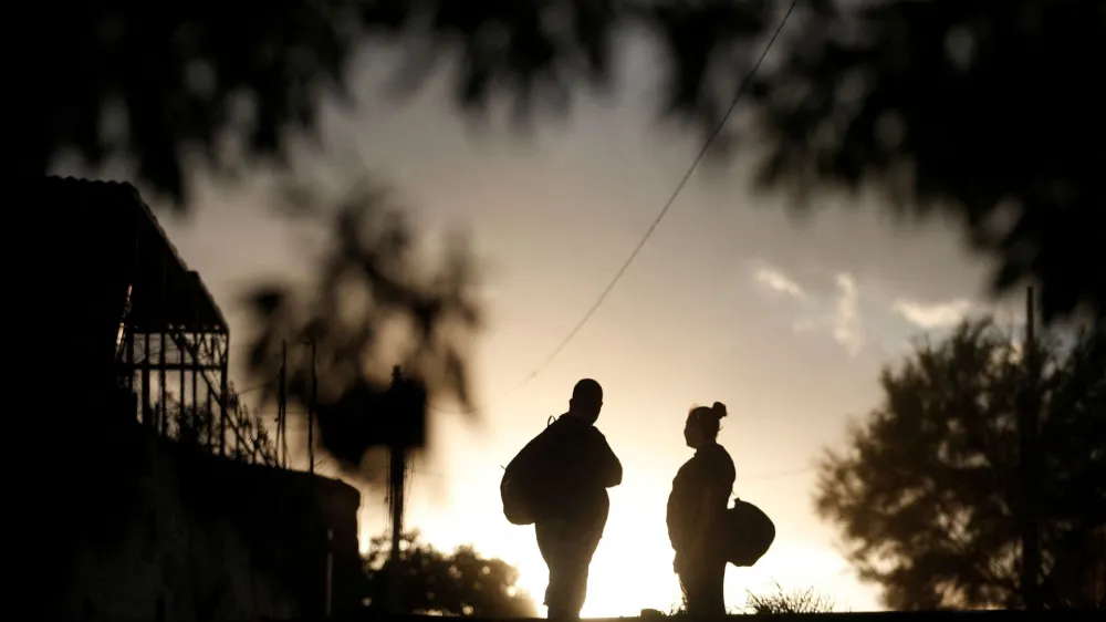 Migrants stand before crossing the Rio Grande river to try to apply for asylum through Eagle Pass, Texas, U.S., in Piedras Negras, Mexico September 27, 2023. REUTERS/Daniel Becerril