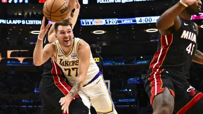 Nov 2, 2025; Los Angeles, California, USA; Los Angeles Lakers guard Luka Doncic (77) passes the ball against Miami Heat guard Pelle Larsson (9) during the second half at Crypto.com Arena. Mandatory Credit: Jonathan Hui-Imagn Images