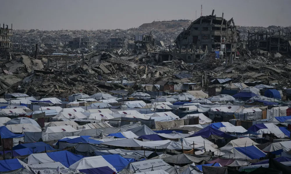 Tents sheltering displaced Palestinians stand amid the destruction left by the Israeli air and ground offensive in Gaza City Friday, Dec. 5, 2025. (AP Photo/Abdel Kareem Hana)