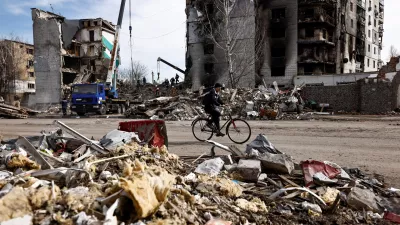 A man rides a bicycle past buildings that were destroyed by Russian shelling, amid Russia's Invasion of Ukraine, in Borodyanka, Kyiv region, Ukraine April 7, 2022. REUTERS/Zohra Bensemra