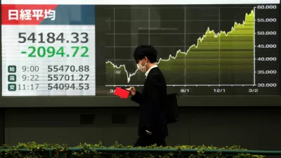 A man walks past a screen displaying Japan's Nikkei share average and graph showing recent movements, outside a brokerage in Tokyo, Japan March 4, 2026. REUTERS/Issei Kato