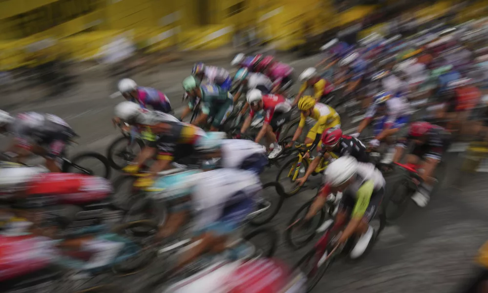 The pack with Slovenia's Tadej Pogacar, wearing the overall leader's yellow jersey, rides during the twenty-first stage of the Tour de France cycling race over 132.3 kilometers (82.1 miles) with start in Mantes-la-Ville and finish on the Champs-Elysees in Paris, France, Sunday, July 27, 2025. (AP Photo/Thibault Camus)