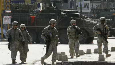 U.S. soldiers from the 172nd Stryker Brigade Combat Team patrol a road in Baghdad in this October 27, 2006 file photo. President George W. Bush will tell skeptical Americans on January 10, 2007 he will send about 21,500 extra U.S. troops to Iraq and admit it was a mistake not to have more forces fighting the unpopular war in the past. REUTERS/Mahmoud Raouf Mahmoud/Files (IRAQ)