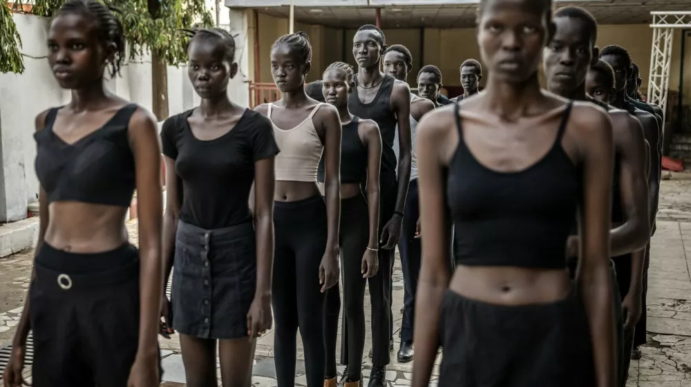 Professional models from the Juba-based modelling agency Jubalicious listen to instructions from a coach during a modelling training session at a hotel in Juba on February 19, 2026. Heels click on cracked paving stones as fantastically long-limbed men and women practice moves they hope will whisk them away from South Sudan, one of the fashion world's favourite scouting locations.Many hope to follow in the footsteps of their compatriot Awar Odhiang, who went from a refugee camp in Ethiopia to closing Chanel's Paris Fashion Week show last year. South Sudan has been mired in conflict, poverty and corruption since its independence in 2011, but the success of its models has been a ray of positivity. No less than nine of the top 50 models currently listed on Models.com are originally from the east African country.,Image: 1082447914, License: Rights-managed, Restrictions: TO GO WITH AFP STORY BY Rose TROUP BUCHANAN, Model Release: no