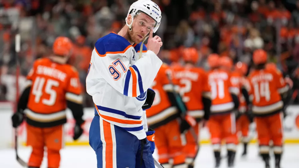 Edmonton Oilers center Connor McDavid wipes his visor as members of the Anaheim Ducks celebrate after they were defeated in Game 6 in the first round of the NHL hockey Stanley Cup playoffs series Thursday, April 30, 2026, in Anaheim, Calif. (AP Photo/Mark J. Terrill) / Foto: Mark J. Terrill
