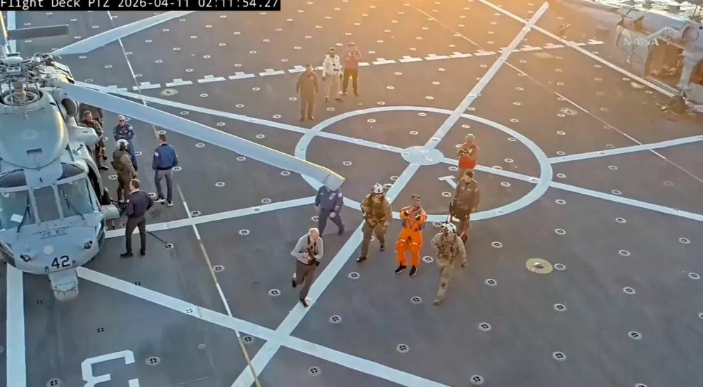 Crew member Victor Glover applauds aboard the recovery ship after being extracted from the Artemis II capsule by recovery personnel in the Pacific Ocean in this screengrab from a livestream video after the Artemis II crew's flyby of the Moon, April 10, 2026. NASA/Handout via REUTERS THIS IMAGE HAS BEEN SUPPLIED BY A THIRD PARTY. OVERLAY FROM THE SOURCE.