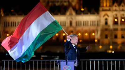 Peter Magyar, the leader of the opposition Tisza party waves a national flag after a parliamentary election in Budapest, Hungary, Sunday, April 12, 2026. (AP Photo/Darko Bandic)