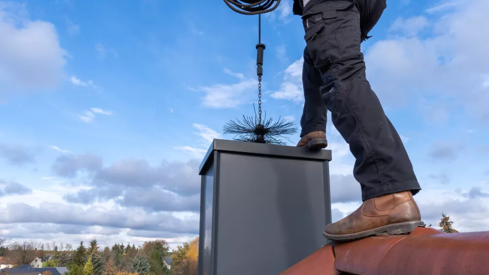 chimney sweep with stovepipe hat upon the roof