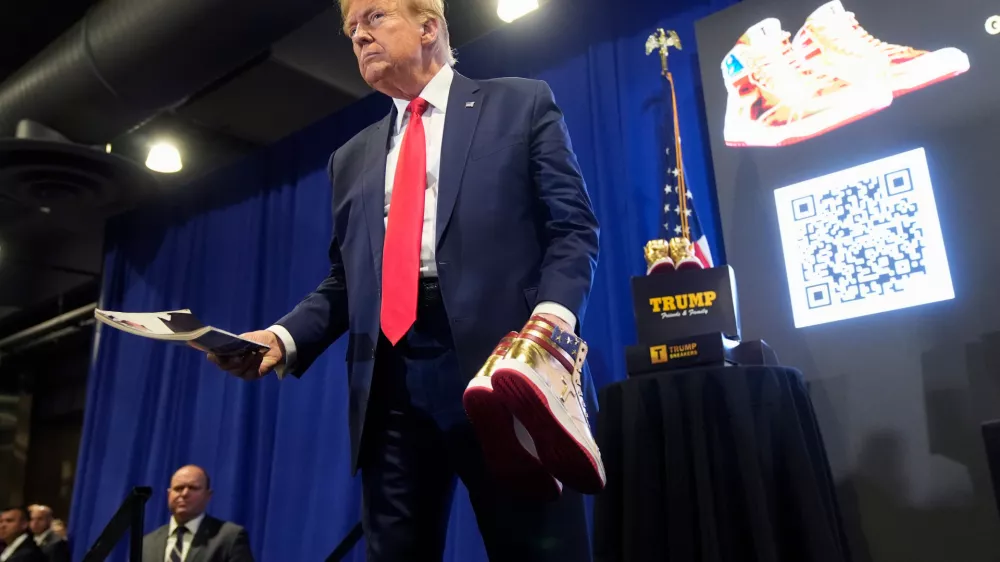 FILE - Donald Trump hold a Playboy magazine and gold Trump sneakers at Sneaker Con Philadelphia, an event popular among sneaker collectors, in Philadelphia, Saturday, Feb. 17, 2024. (AP Photo/Manuel Balce Ceneta, File)