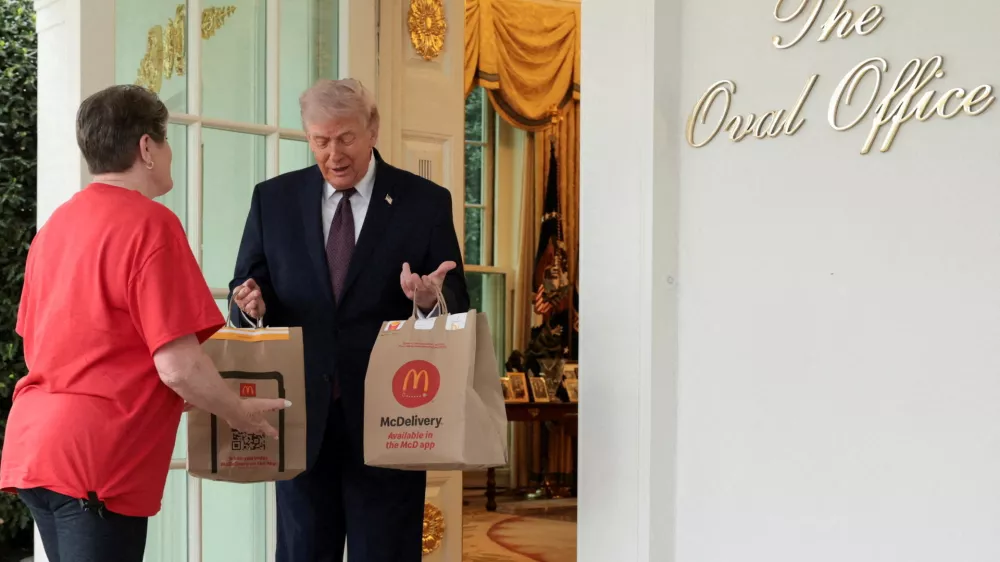 U.S. President Donald Trump receives a McDonald's delivery via DoorDash from Sharon Simmons outside the Oval Office at the White House, in Washington, D.C., U.S., April 13, 2026. REUTERS/Jonathan Ernst    TPX IMAGES OF THE DAY