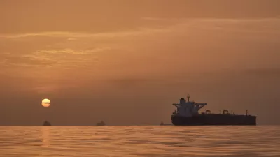 The sun rises behind tankers anchored in the Strait of Hormuz off the coast of Qeshm Island, Iran, Saturday, April 18, 2026. (AP Photo/Asghar Besharati)
