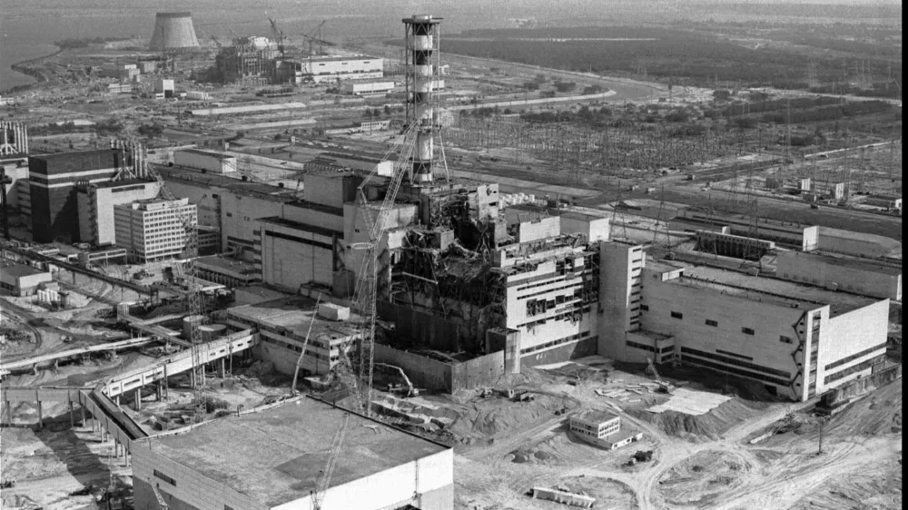 FILE - This 1986 file photo shows an aerial view of the Chernobyl nuclear plant in Chernobyl, Ukraine showing damage from an explosion and fire in reactor four on April 26, 1986 that sent large amounts of radioactive material into the atmosphere. A massive shelter has finally been installed over the exploded reactor at the Chernobyl nuclear plant, one of the most ambitious engineering projects in the world. The half-cylinder-shaped shelter began being moved toward the reactor on a system of hydraulic jacks two weeks ago and reached its destination Tuesday, Nov. 29, 2016 a significant step toward liquidating the remains of the world's worst nuclear accident, 30 years ago in what is now Ukraine. (AP Photo/Volodymyr Repik, File) / Foto: Volodymyr Repik