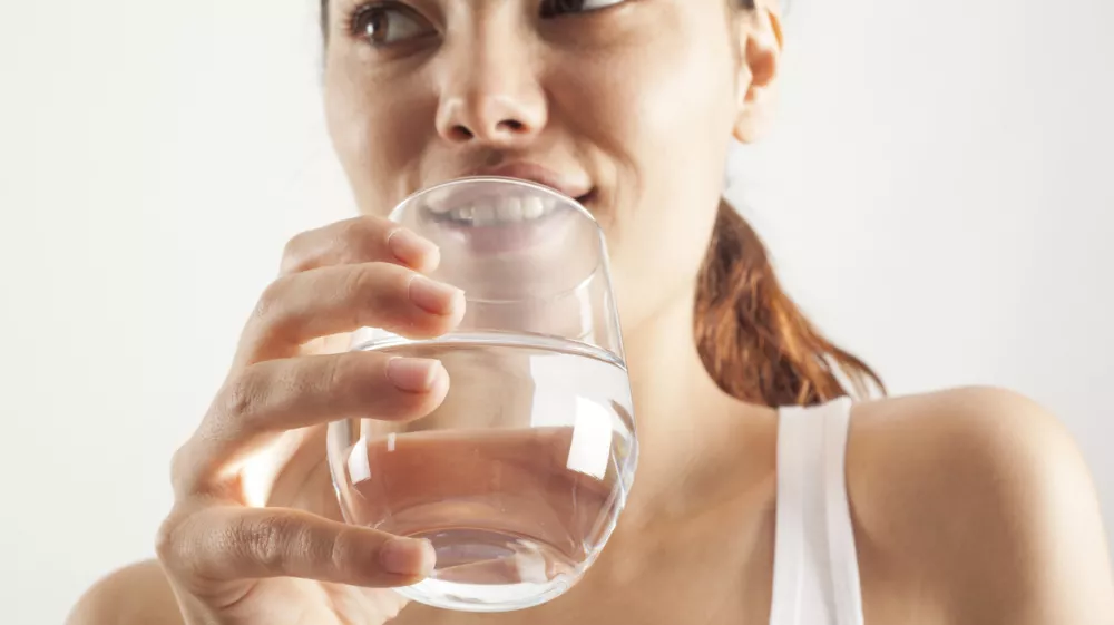 Young woman drinking glass of water