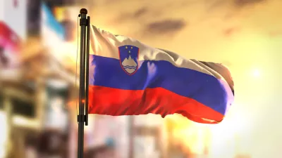 Slovenia Flag Against City Blurred Background At Sunrise Backlight