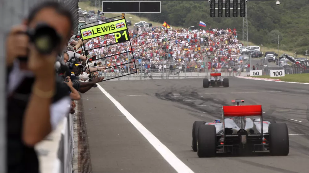 McLaren Mercedes driver Lewis Hamilton of Britain is seen in background after crossing the finish line to win the Turkish Formula One Grand Prix at the Istanbul Park circuit racetrack, in Istanbul, Turkey, Sunday, May 30, 2010. In foreground is seen second place McLaren Mercedes driver Jenson Button of Britain. (AP Photo/Thanassis Stavrakis)
