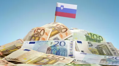 The national flag of Slovenia sticking in a pile of mixed european banknotes.(series) / Foto: Eyegelb