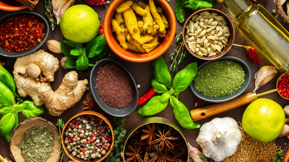 A visually striking arrangement of fresh spices and herbs on a brown surface, highlighting their vivid colors, intricate details and rich culinary essence, banner / Foto: Pundapanda