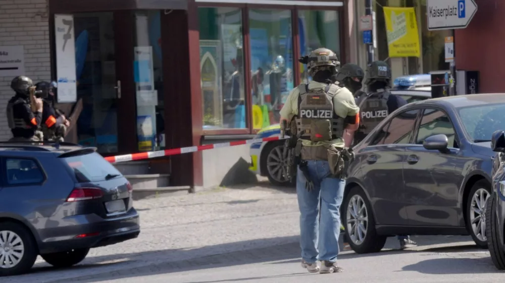 08 May 2026, Rhineland-Palatinate, Sinzig: Police officers stand at the scene. According to initial police reports, a hostage situation has occurred at a bank branch in Sinzig, Rhineland-Palatinate. The emergency services are on the scene with a large contingent in the Ahrweiler district. Photo: Thomas Frey/dpa,Image: 1097318057, License: Rights-managed, Restrictions: GERMANY OUT, Model Release: no