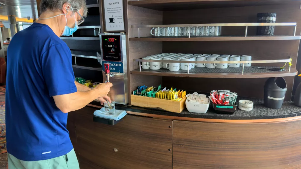 A passenger on the hantavirus-stricken cruise ship, MV Hondius, helps himself to water at the ship's self-service area during the voyage to Spain's port of Tenerife, May 6, 2026. (AP Photo)