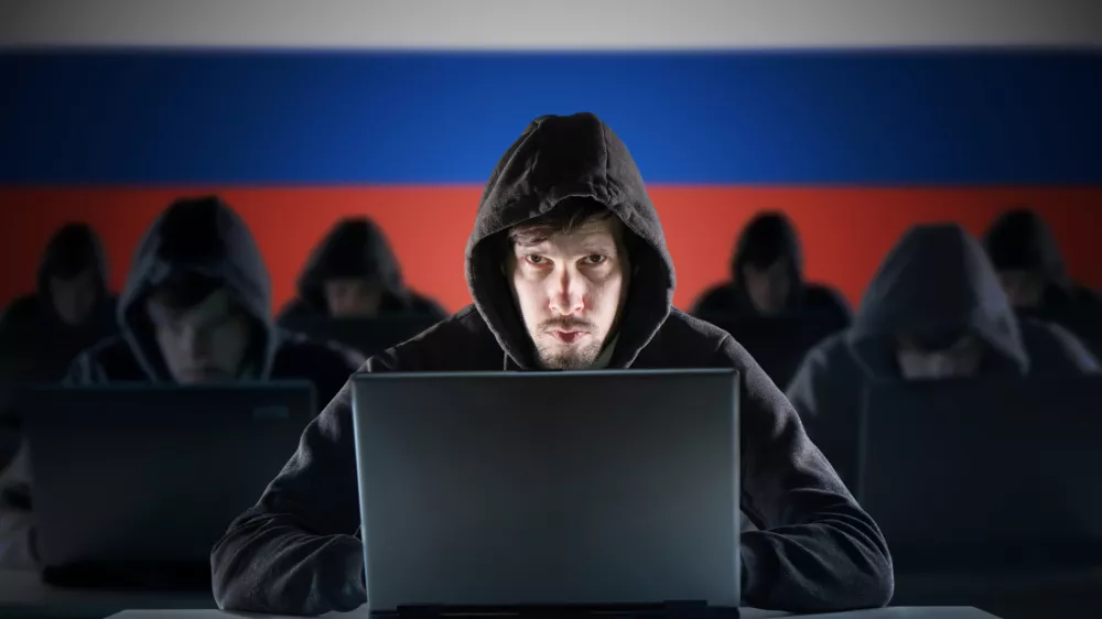 Many russian hackers in troll farm. Cyber crime and security concept. Russia flag in background.