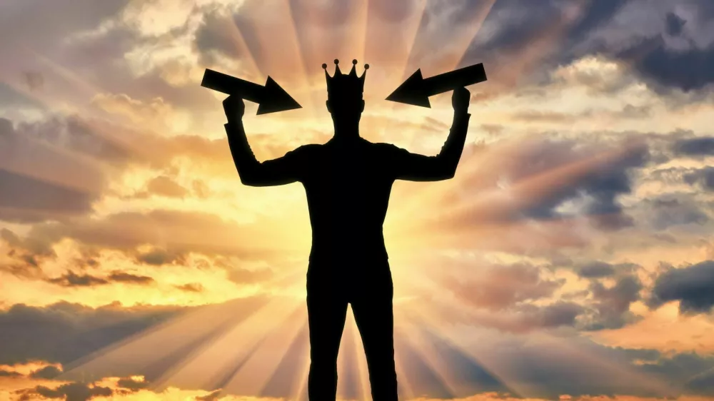 Silhouette of a selfish man with a crown on his head tries to attract attention by holding pointer in his hands. The concept of a selfish and narcissistic personality