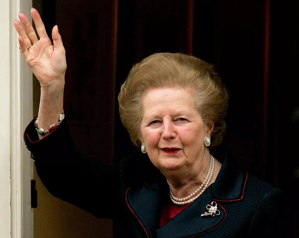 Britain's former Prime Minister Baroness Margaret Thatcher waves at the media as she arrives at her London home after leaving hospital December 8, 2005. Thatcher left hospital on Thursday following an overnight stay after being admitted for feeling faint. REUTERS/Kieran Doherty