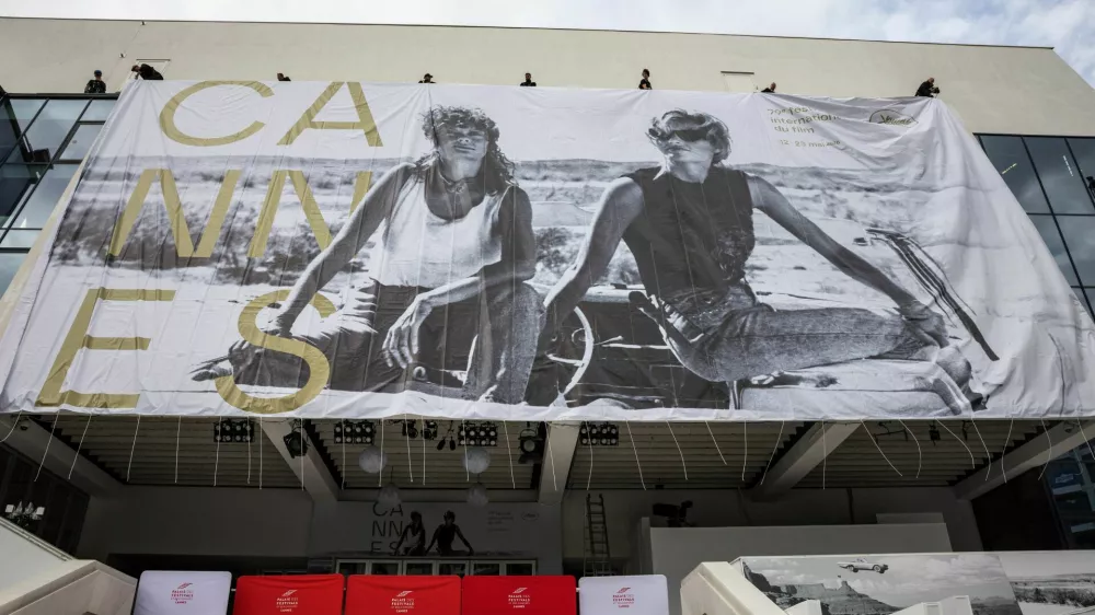 Workers set up a giant canvas of the official poster featuring actors Geena Davis and Susan Sarandon from Ridley Scott's road movie "Thelma & Louise" on the facade of the Festival palace before the start of the 79th Cannes Film Festival in Cannes, France, May 10, 2026. REUTERS/ Marko Djurica