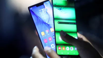 A person holds two new Huawei Mate 30 smartphones at the Convention Center in Munich, Germany September 19, 2019. REUTERS/Michael Dalder