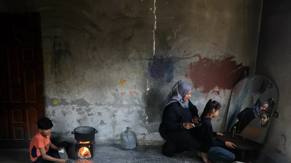 Palestinian Zainab Abu Samaan combs her daughter's hair inside their damaged house, at Shati (Beach) refugee camp in Gaza City, May 10, 2026. REUTERS/Dawoud Abu Alkas   TPX IMAGES OF THE DAY / Foto: Dawoud Abu Alkas