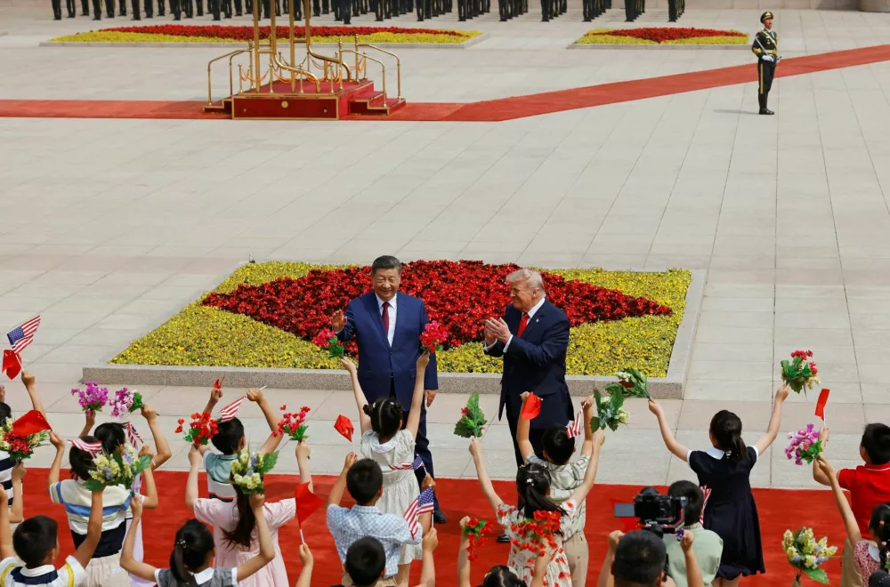 Children hold Chinese and U.S. flags during the welcome ceremony for U.S. President Donald Trump by Chinese President Xi Jinping, at the Great Hall of the People in Beijing, China May 14, 2026. REUTERS/Maxim Shemetov/Pool