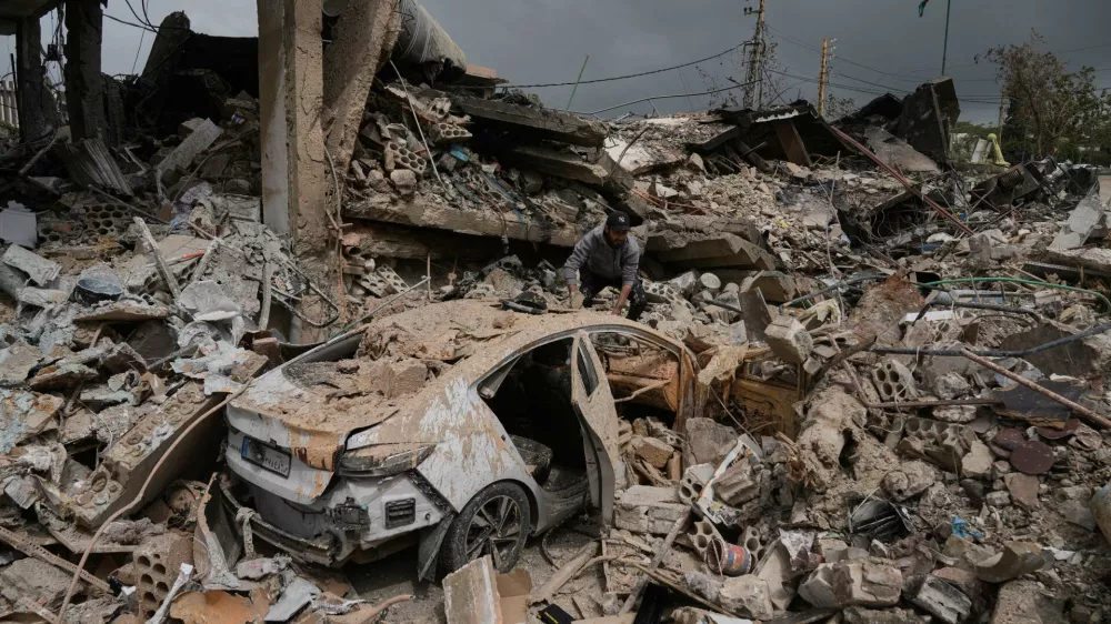 A man inspects his damaged car amid the rubble of shops destroyed in previous Israeli airstrikes in the Hosh neighborhood of Tyre, southern Lebanon, April 19, 2026. (AP Photo/Bilal Hussein)