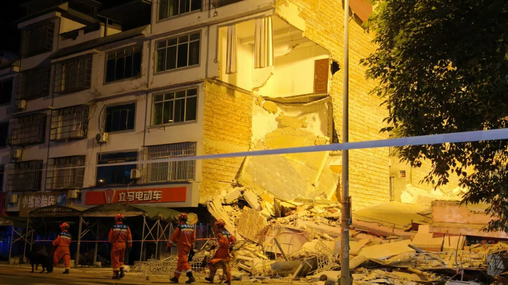 Rescue workers walk past a damaged building following an earthquake at Taiyang village in Liuzhou, Guangxi Zhuang Autonomous Region, China May 18, 2026. cnsphoto via REUTERS  ATTENTION EDITORS - THIS IMAGE WAS PROVIDED BY A THIRD PARTY. CHINA OUT. NO COMMERCIAL OR EDITORIAL SALES IN CHINA