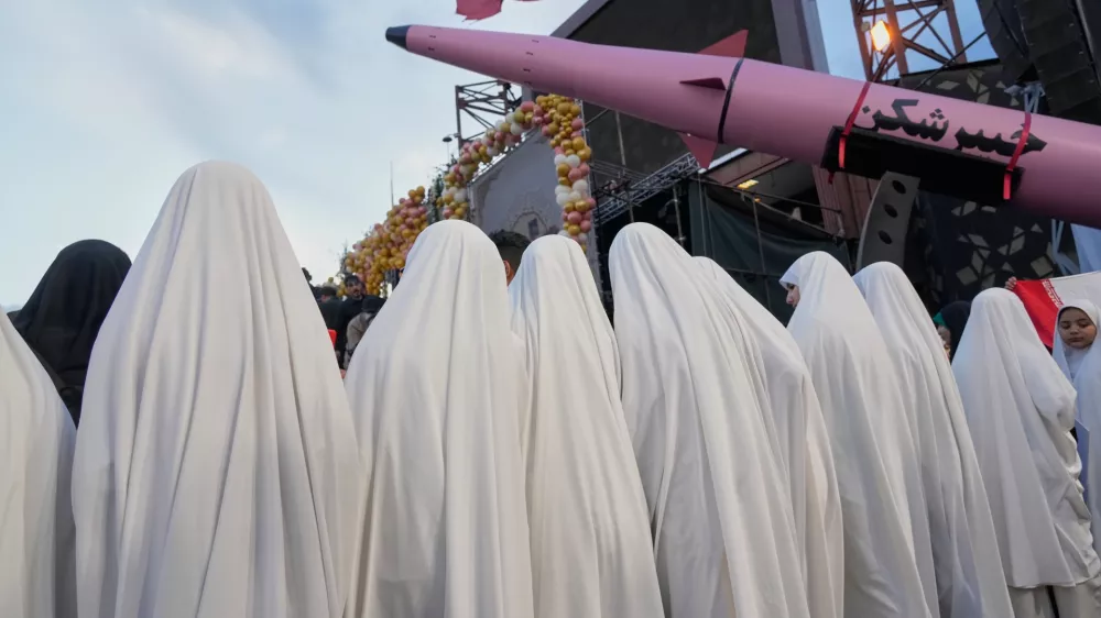 A group of girls stand beside a "Khaybar-buster" missile during a mass wedding ceremony for couples participating in the "Janfada" ("Sacrifice for Iran") pro-government campaign in Tehran, Iran, Monday, May 18, 2026. (AP Photo/Vahid Salemi)