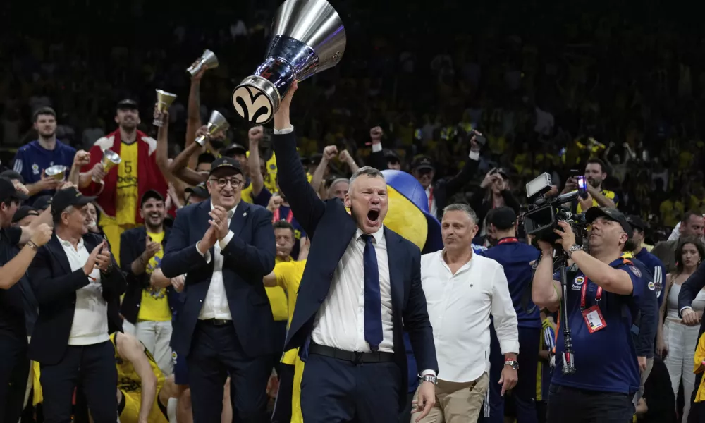 Fenerbahce's head coach Saras Jasikevicius holds the trophy as they celebrate winning the Euroleague final basketball match between Monaco and Fenerbahce in Abu Dhabi, United Arab Emirates, Sunday, May 25, 2025. (AP Photo/Altaf Qadri)