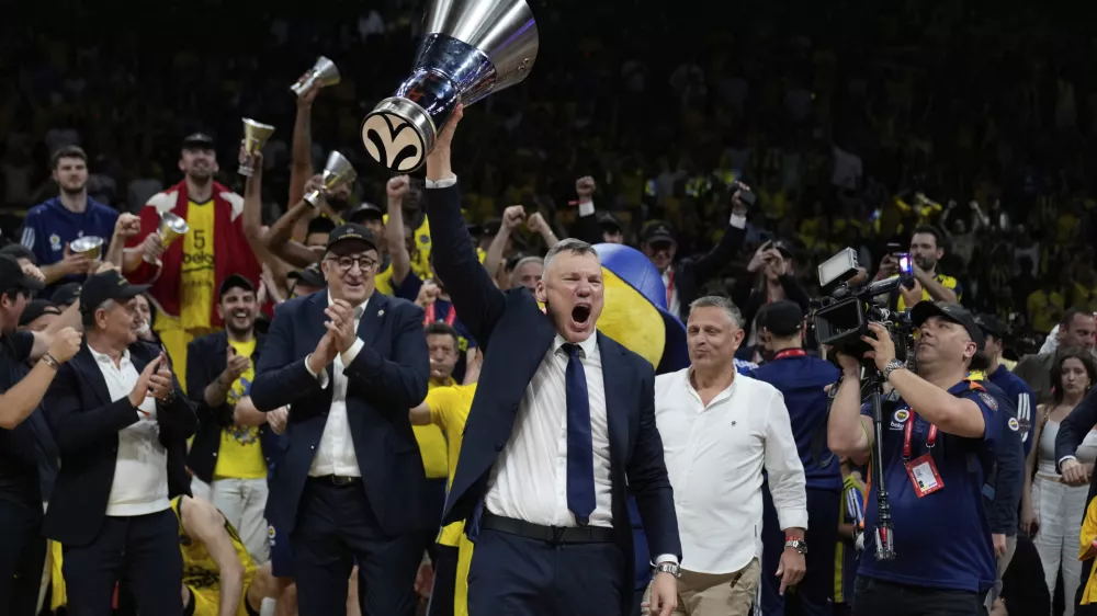Fenerbahce's head coach Saras Jasikevicius holds the trophy as they celebrate winning the Euroleague final basketball match between Monaco and Fenerbahce in Abu Dhabi, United Arab Emirates, Sunday, May 25, 2025. (AP Photo/Altaf Qadri)