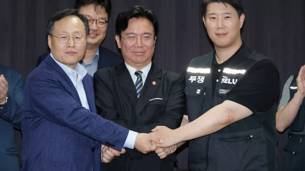 Choi Seung-ho, head of Samsung Electronics union, Yeo Myung-koo, head of the People Team under Samsung's Device Solutions division and the company's chief management negotiator, and Labour Minister Kim Young-hoon pose for photographs after reaching tentative pay deal in Suwon, South Korea, May 20, 2026. Yonhap/via REUTERS    ATTENTION EDITORS - THIS IMAGE HAS BEEN SUPPLIED BY A THIRD PARTY. NO RESALES. NO ARCHIVE. SOUTH KOREA OUT. NO COMMERCIAL OR EDITORIAL SALES IN SOUTH KOREA.   TPX IMAGES OF THE DAY