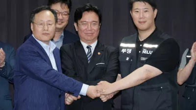 Choi Seung-ho, head of Samsung Electronics union, Yeo Myung-koo, head of the People Team under Samsung's Device Solutions division and the company's chief management negotiator, and Labour Minister Kim Young-hoon pose for photographs after reaching tentative pay deal in Suwon, South Korea, May 20, 2026. Yonhap/via REUTERS    ATTENTION EDITORS - THIS IMAGE HAS BEEN SUPPLIED BY A THIRD PARTY. NO RESALES. NO ARCHIVE. SOUTH KOREA OUT. NO COMMERCIAL OR EDITORIAL SALES IN SOUTH KOREA.   TPX IMAGES OF THE DAY