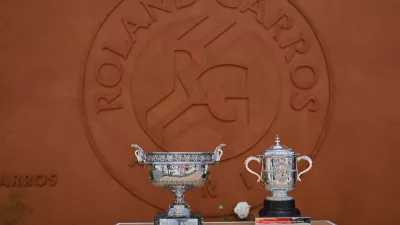 The men's, left, and women's trophies are displayed in-front of the Roland-Garros logo during qualifications for the French Open tennis tournament in Paris, Friday, May 22. (AP Photo/Emma Da Silva)
