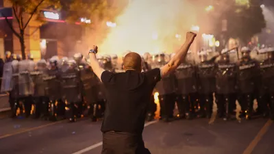 An anti-government protester taunts riot police during a rally led by Serbia's protesting university students who are pushing for major political changes in the Balkan country run by President Aleksandar Vucic, in Belgrade, Serbia, Saturday, May. 23, 2026. (AP Photo/Armin Durgut)