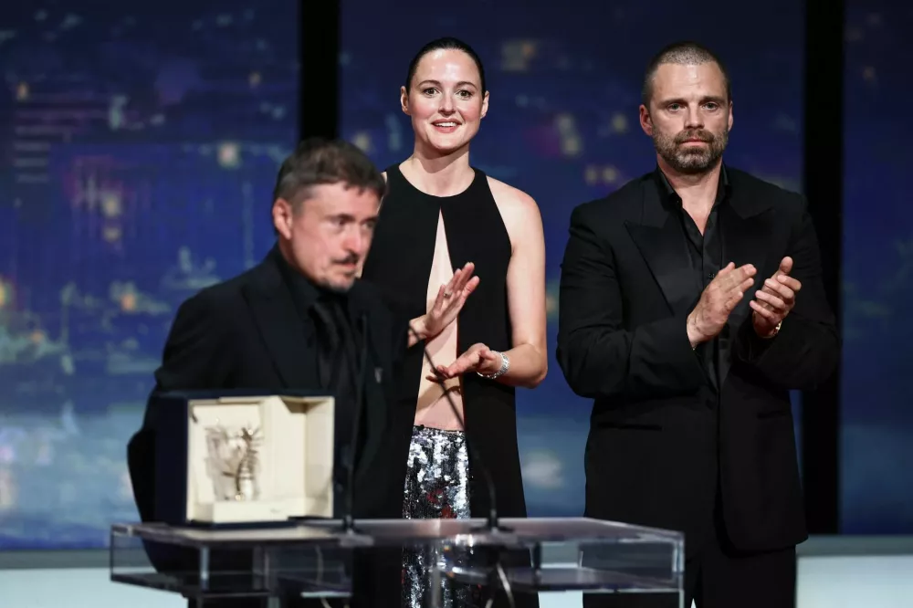 Director Cristian Mungiu, Palme d'Or award winner for the film "Fjord", next to cast members Renate Reinsve and Sebastian Stan, speaks on stage during the closing ceremony of the 79th Cannes Film Festival in Cannes, France, May 23, 2026. REUTERS/Sarah Meyssonnier
