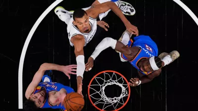 San Antonio Spurs forward Victor Wembanyama (1) drives to the basket against Oklahoma City Thunder center Chet Holmgren (7) and guard Shai Gilgeous-Alexander (2) during the first half in Game 4 in the Western Conference finals NBA basketball playoffs series in San Antonio, Sunday, May 24, 2026. (AP Photo/Eric Gay)