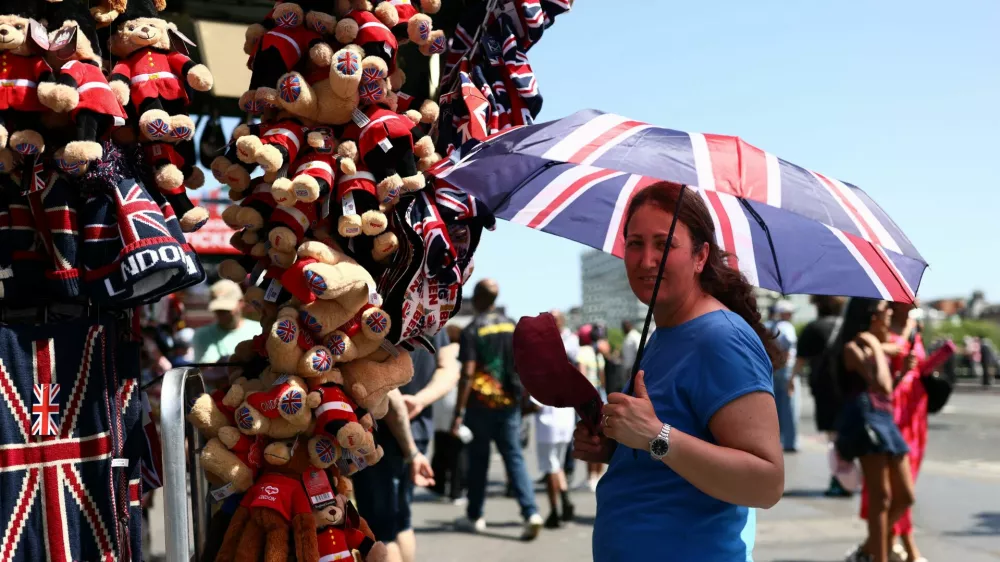 A gift stall worker shields herself from the sun with a Union Jack umbrella during a heatwave, after the UK recorded its hottest May bank holiday ever, in London, Britain, May 26, 2026. REUTERS/Jack Taylor / Foto: Jack Taylor