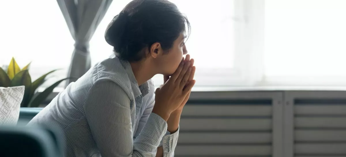 Pensive millennial Indian girl sit on couch at home look in distance thinking pondering, thoughtful young ethnic woman lost in thoughts feel stressed suffer from depression or emotional breakdown / Foto: Fizkes